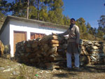 Bestellen Sie baut Schule in der Nähe Rudraprayag - Der Schuldirektor mit den Baumaterialien und der Schule (zum Vergrößern anklicken)